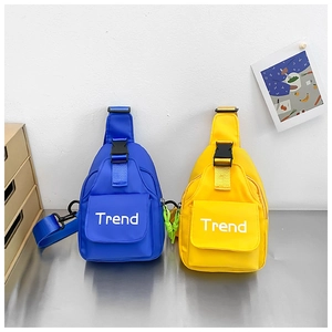 Detail of yellow and blue kids canvas chest bags with Trend letter prints and buckles