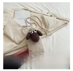 Detail of handmade crochet sheep crossbody bag with cute 3D ears and woven strap