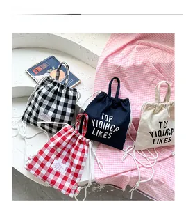 Detail view of four mini canvas drawstring backpacks with checkered patterns for kids