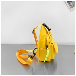 Side view of yellow kids canvas chest bag with front pocket and adjustable buckle strap