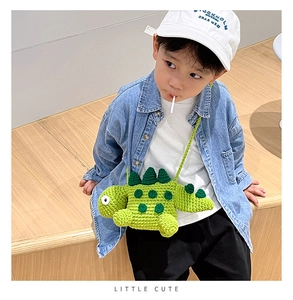 Detailed view of hand-knitted green dinosaur crossbody bag worn by a young child