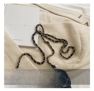 Dettaglio della borsa a tracolla in denim trapuntato con catena in metallo dorato