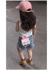 Vue arrière d'un enfant portant un sac bandoulière à nœud rose et une casquette assortie