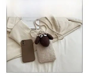 Handmade crochet sheep phone bag showing size comparison with a mobile phone