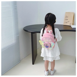 Détail d'un sac à dos rose pour enfants avec paillettes et ailes de papillon 3D