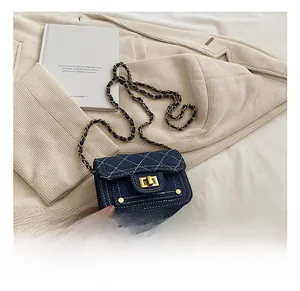 Dettaglio mini borsa in denim trapuntato con catena dorata e chiusura a girello