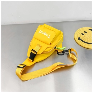 Detail of bright yellow kids chest bag with Trend logo and neon green zipper puller