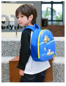 Blauer Kinderrucksack mit Hartschale und gelben Baufahrzeug-Motiven beim Tragen