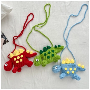 Close-up of three handmade knitted dinosaur crossbody bags in red, green and blue colors