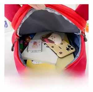 Internal view of the red toddler backpack showing books and school supplies inside
