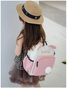 Detail des Kinder-Panda-Rucksacks mit rosa Kontrastfarben und Plüschkugel-Anhänger