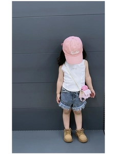 Détail du petit sac rose à bandoulière en chaîne porté sur une tenue d'été pour enfant