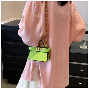 Mini borsa in pelle verde fluorescente con catena dorata indossata dalla modella