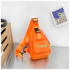 Detail of vibrant orange nylon kids chest bag with green Trend logo and buckle strap