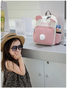 Detail eines rosa-weißen Panda-Rucksacks mit Stickerei und seitlicher Trinkflaschentasche