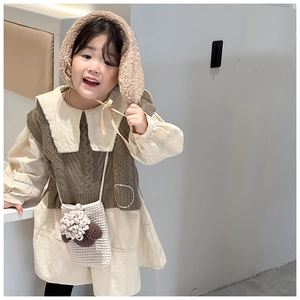Detailed view of child wearing a handmade knitted sheep crossbody bag with a fuzzy ear hat