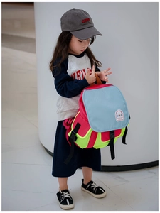 Detail of color-block canvas kids backpack with adjustable straps on child model
