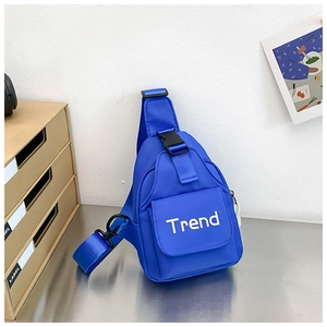 Close-up of bright blue nylon chest bag featuring white Trend lettering and black buckle