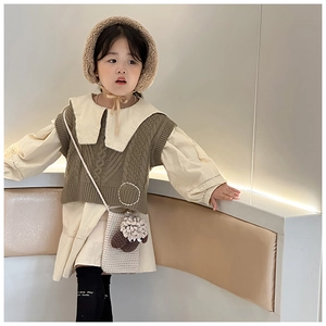 Detailed view of child's handmade knit lamb crossbody bag with warm autumn winter outfit