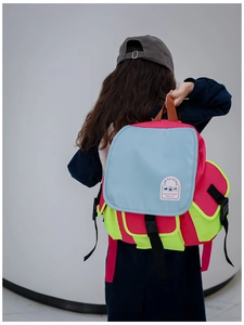 Detail view of colorful patchwork canvas backpack with adjustable straps and logo patch