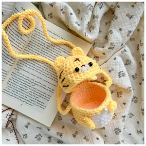 Détail du sac bandoulière tigre tricoté main avec bouton perle et bandoulière tissée