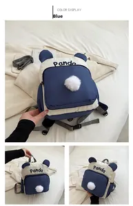 Detailansicht des blauen Panda-Rucksacks mit Plüschbommel und Stickerei auf Nylonstoff