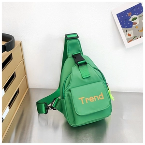 Detailed view of neon green kids sling bag with orange Trend logo and secure buckle strap