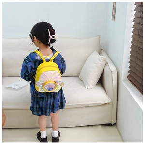 Détail du sac à dos jaune pour enfants avec ailes de papillon et patch Elsa