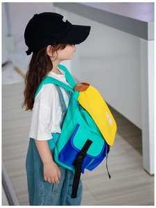 Side view of kid wearing the colorful canvas backpack with blue, yellow and green contrast