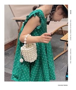 Detail shot of white pearl woven bucket bag with pearl handle for girls summer fashion