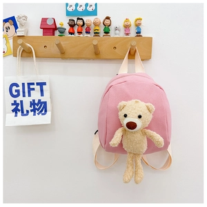 Detailed view of pink canvas toddler backpack featuring a 3D plush bear and woven straps