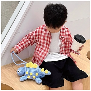 Detail of handmade crochet blue dinosaur crossbody bag with yellow felt plates for kids