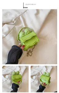 Détail du mini sac à main vert avec nœud, imprimé NIE et bandoulière chaîne dorée