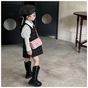 Dettaglio di una bambina con abito in tweed, basco in pelle trapuntata e stivaletti