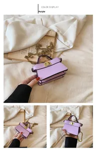 Dettaglio mini borsa a trapezio viola con tracolla a catena dorata e chiusura a girello