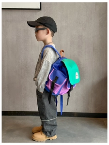 Detail view of colorful patchwork kid backpack with buckle closure and side pockets