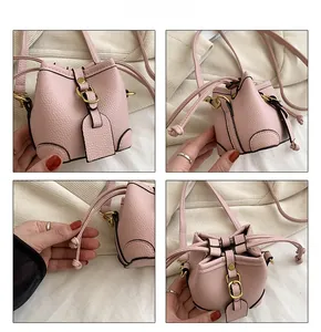 Detail view of pink mini bucket bag with litchi texture leather and drawstring closure