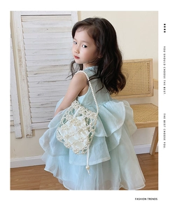 Détail du sac à main pour enfant en perles blanches et robe en tulle bleu