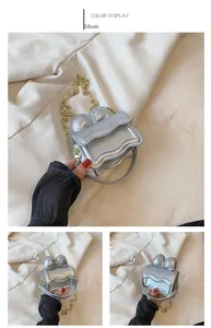 Détail du mini sac argenté avec nœud et chaîne dorée pour petite fille
