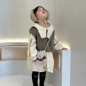 Cute girl knitting crossbody bag with autumn dress vest and cozy earmuff hat outfit