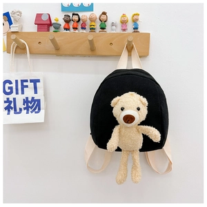 Close-up of black canvas kids backpack featuring a 3D plush bear on a wooden hook