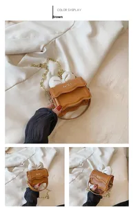 Vue détaillée du mini sac bandoulière marron avec nœud blanc et chaîne dorée