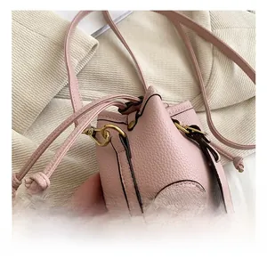 Detail of pink mini drawstring bucket bag showing high-quality gold metal hooks and texture
