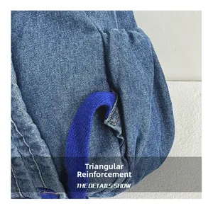 Detail of reinforced triangle stitching on denim backpack strap for extra durability