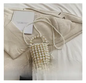 Detailed view of woven pearl bucket bag with gold beads and drawstring closure