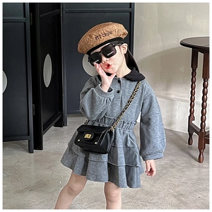 Dettaglio dell'abito in maglia grigia per bambina con gonna a balze e borsa a catena