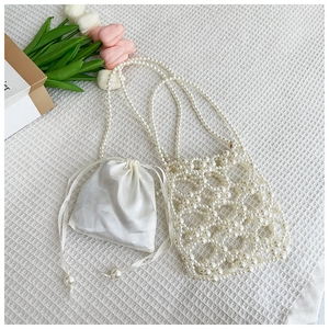 Détail d'un sac à main en perles tissées avec une doublure en satin sur tissu blanc