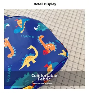 Detail of soft blue fabric with colorful cartoon dinosaur patterns and roar text