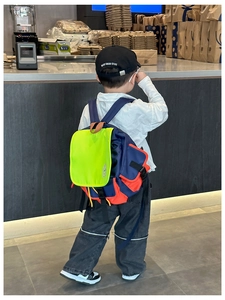 Detail of child wearing the color-block nylon backpack with adjustable straps and side pockets