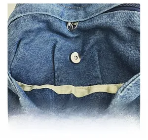 Detail shot of the magnetic snap button closure on this blue denim kid backpack